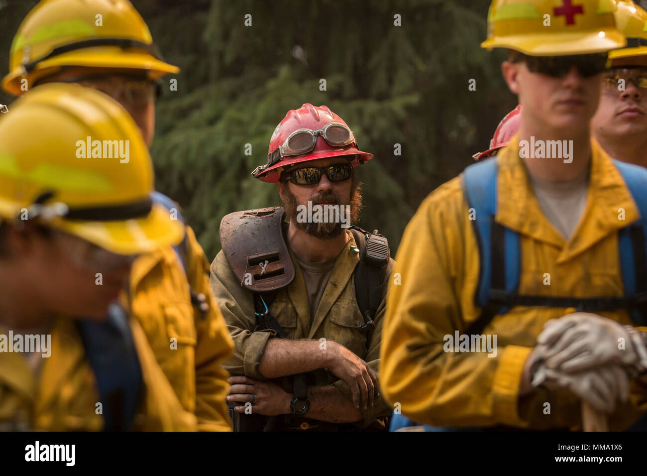 Firefighters from the Devil's Canyon Hand Crew work alongside U.S. Army Soldiers, assigned to 23rd Brigade Engineer Battalion, 1-2 Stryker Brigade Combat Team, to combat wild fires in the Umpqua National Forest, Oregon, Sept. 11. The Soldiers have been clearing flammable brush and debris in order to halt the advance of the flames. (U.S. Army photos by Pvt. Adeline Witherspoon, 20th Public Affairs Detachment) Stock Photo