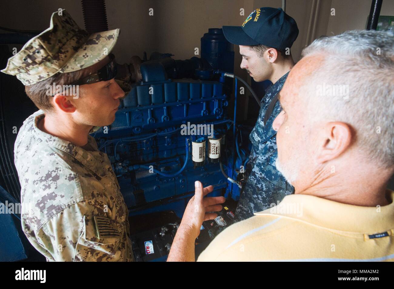 170926-N-IM651-009  ARECIBO, Puerto Rico (Sept. 26, 2017) Construction Electrician 3rd Class Joshua Reding, left, assigned to Construction Battalion Maintenance Unit (CBMU) 202, and Machinist Mate 3rd Class Bradley Colon, assigned to the amphibious assault ship USS Kearsarge (LHD 3),  inspect a generator at the Hospital  Metropolitano Dr. Susoni in Arecibo, Puerto Rico. The Department of Defense is supporting the Federal Emergency Management Agency, the lead federal agency, in helping those affected by Hurricane Maria to minimize suffering and as one component of the overall whole-of-governmen Stock Photo