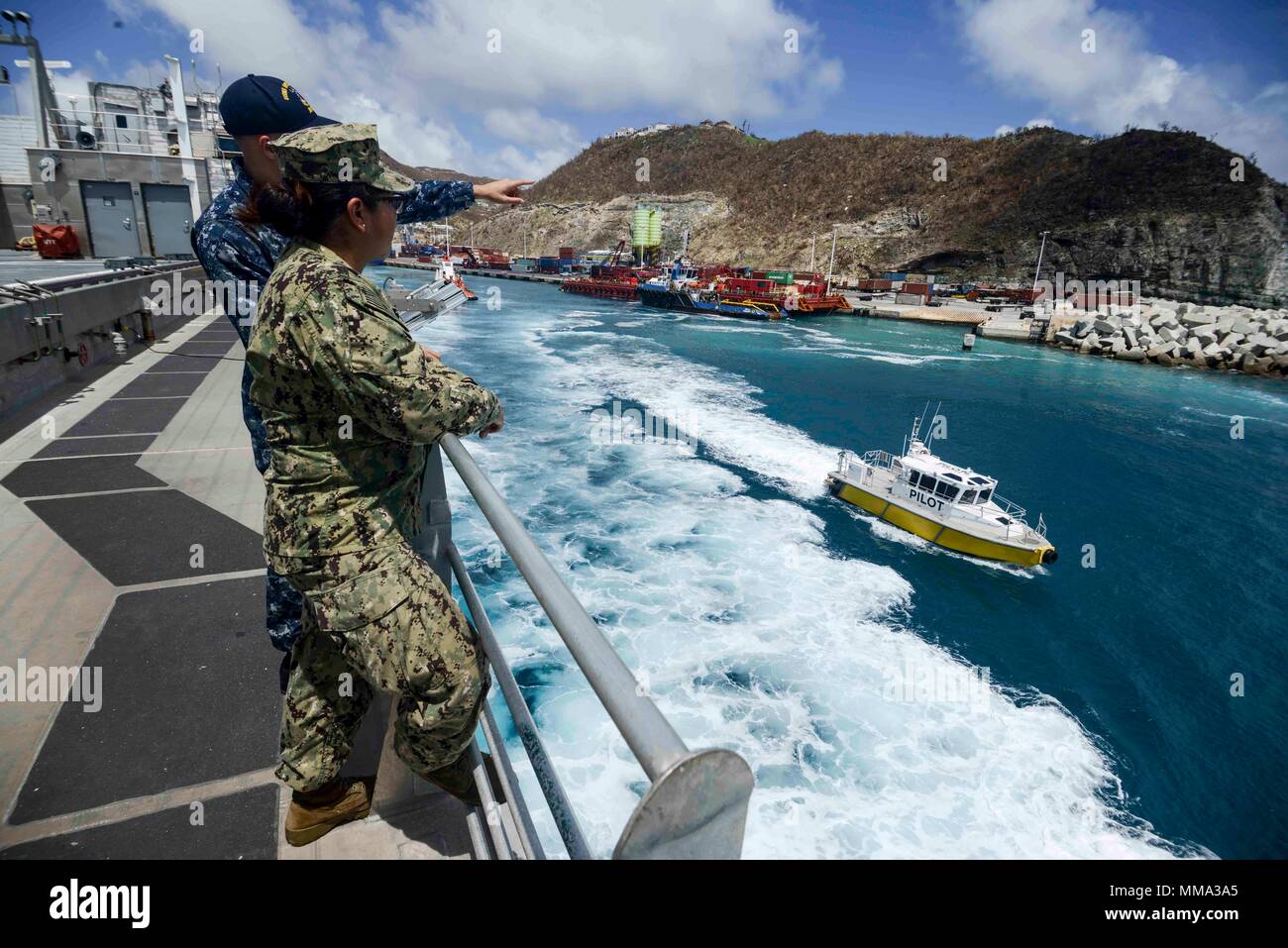 170917-N-KW679-0055 PHILIPSBURG, Sint Maarten (September 17, 2017) Intelligence Specialist 2nd Class Mason Joyner, left, assigned to Naval Information Forces Fleet Intelligence Adaptive Force Pearl Harbor, and Boatswain's Mate 3rd Class Jazmin Chavez, assigned to Navy Cargo Handling Battalion 1, look upon the island of St. Martin after expeditionary fast transport USNS Spearhead’s (T-EPF 1) departure. Spearhead assisted in humanitarian aid and disaster relief efforts for people affected by Hurricane Irma. SPS 17 is a U.S. Navy deployment executed by U.S. Naval Forces Southern Command/U.S. 4th  Stock Photo