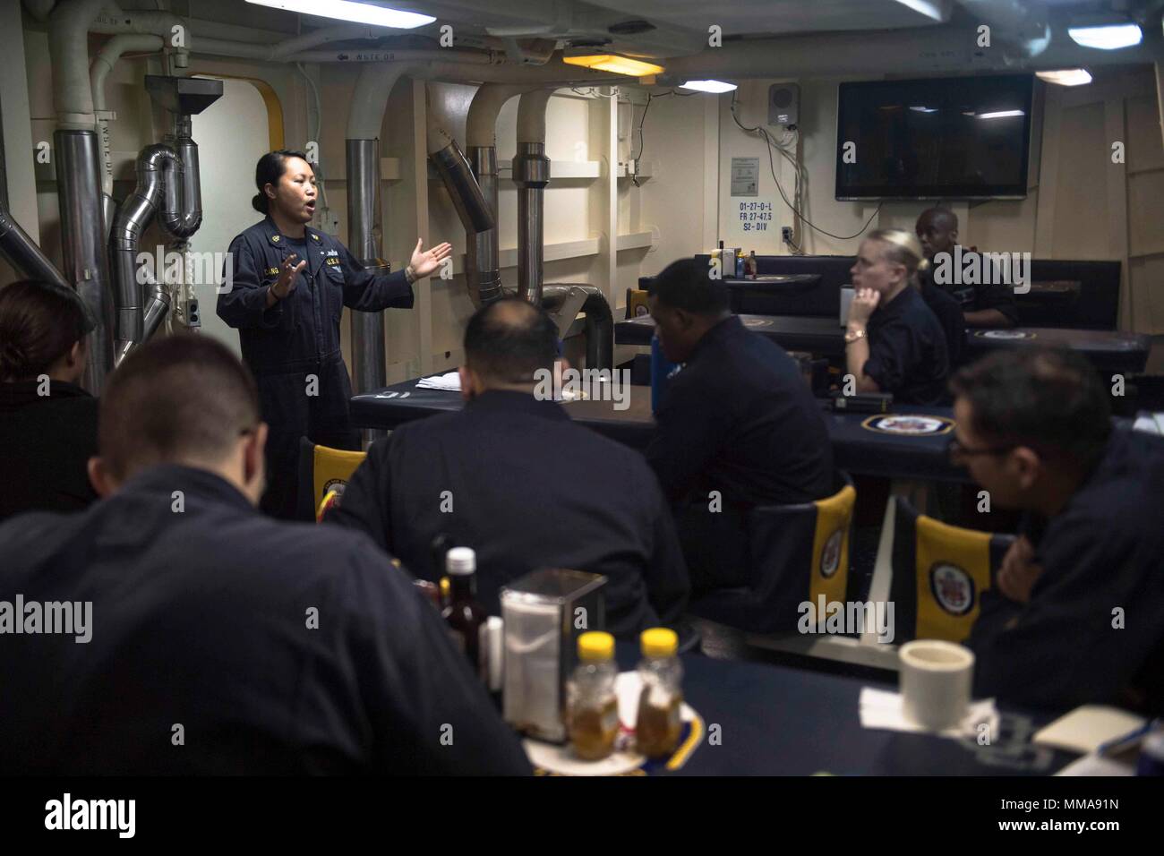 170927-N-BK384-106 MEDITERRANEAN SEA (Sept. 27, 2017) Chief Damage Controlman Susan Dang, from Thornton, Colorado, briefs the damage control training team on the mess decks aboard the San Antonio-class amphibious transport dock ship USS San Diego (LPD 22) Sept. 27, 2017. San Diego is deployed with the America Amphibious Ready Group and the 15th Marine Expeditionary Unit to support maritime security and theater security cooperation in efforts in the U.S. 6th Fleet area of operations. (U.S. Navy photo by Mass Communication Specialist 3rd Class Justin A. Schoenberger/Released) Stock Photo