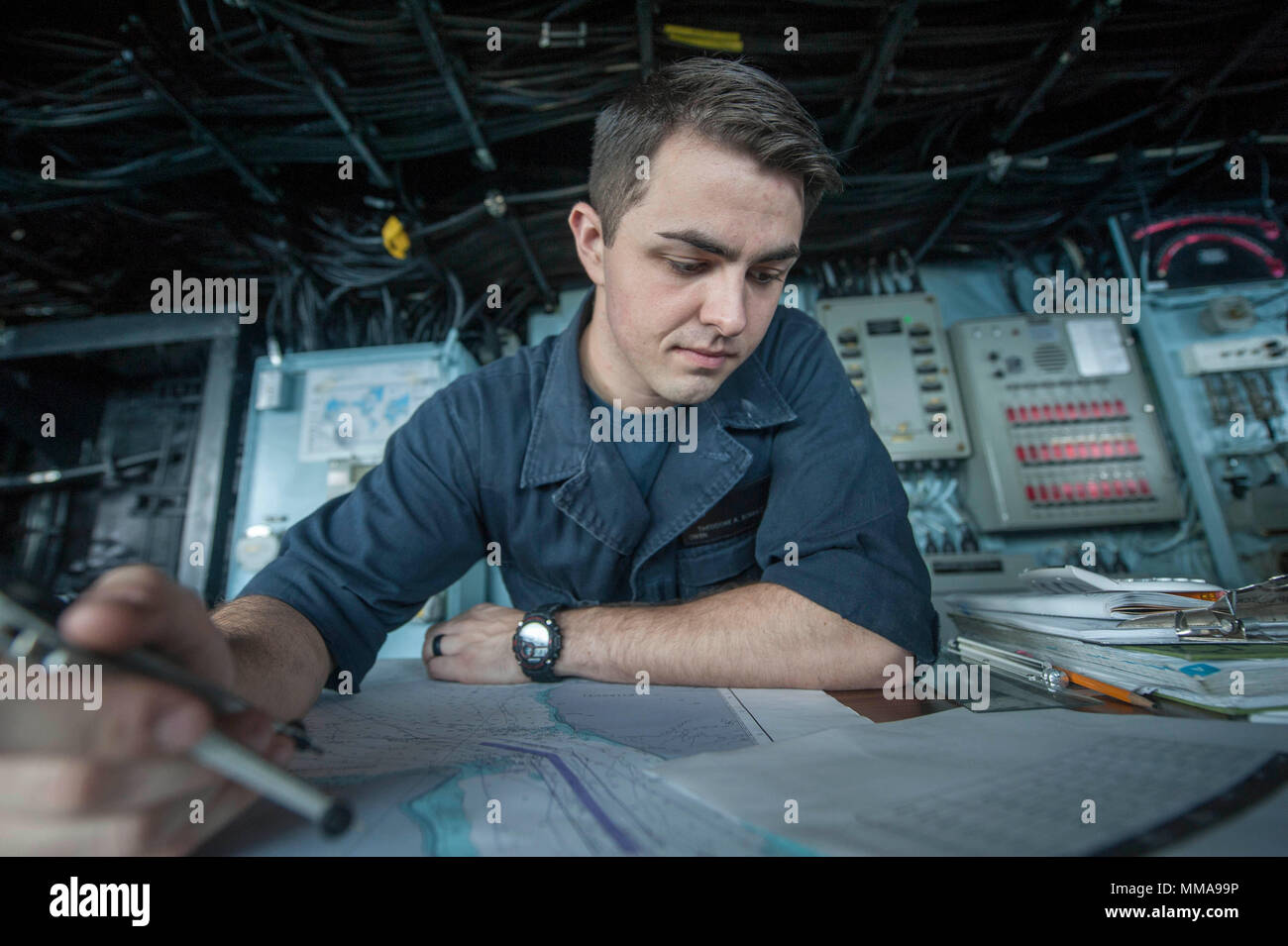 170929-N-ZS023-010 U.S. 5TH FLEET AREA OF OPERATIONS (Sept. 29, 2017) Quartermaster Seaman Ted Schulz, a native of Berryville, Virginia, assigned to the navigation department aboard the amphibious assault ship USS America (LHA 6), plots the ship’s course from the bridge. America is the flagship for the America Amphibious Ready Group and, with the embarked 15th Marine Expeditionary Unit, is deployed to the U.S. 5th Fleet area of operations in support of maritime security operations to reassure allies and partners and preserve the freedom of navigation and the free flow of commerce in the region Stock Photo