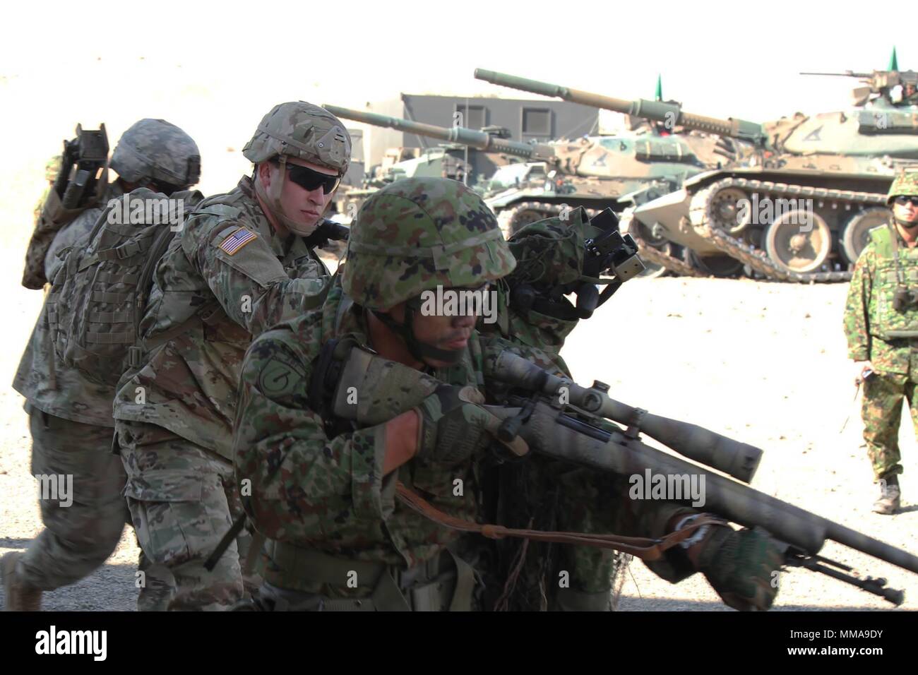 U.S. Army Soldiers with 2nd Battalion, 3rd Infantry Regiment, 1-2 Stryker Brigade Combat Team, and Japan Ground Self-Defense Force train together in squad-level tactics during Rising Thunder 2017 at Yakima Training Center, Washington. The JGSDF and 1-2 SBCT snipers took down simulated targets while Japanese tanks and a U.S. Army Stryker vehicle provided covering fire before a joint strike force cleared the objective. Rising Thunder was held Sept. 5-22. (Photo courtesy of 7th Infantry Division) Stock Photo