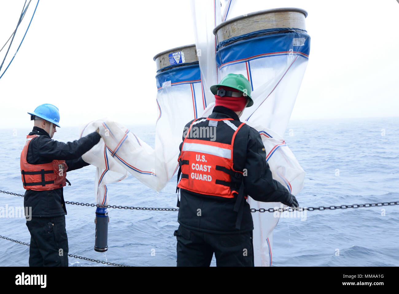 Coast Guard Petty Officer 2nd Class Ed Traver and Coast Guard Seaman Grayden Boad retrieve a bongo net tow after they had been deployed behind the Coast Guard Cutter Healy as part of research operations in the Arctic, Tuesday, Sept. 5, 2017    Used primary to collect samples of zooplankton, this tow consists of four collection nets and is comprised of two larger nets and two smaller nets, with the smaller nets also made out of a finer mesh.    U.S. Coast Guard photo by Petty Officer 3rd Class Amanda Norcross Stock Photo