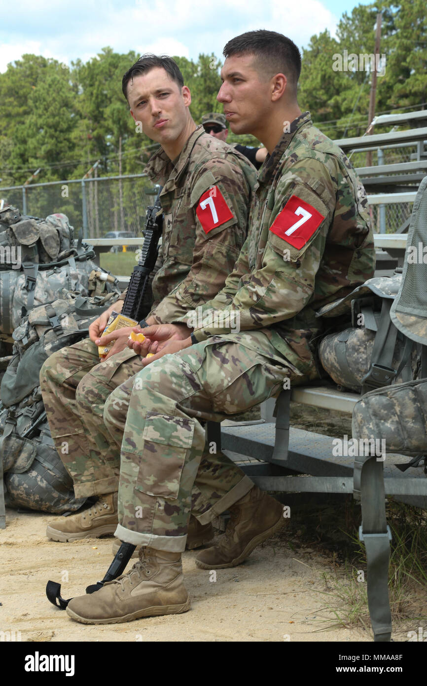 U.S. Army Staff Sgt. Eric Joiner and Staff Sgt. Mkakaquet Genereaux, assigned to the Lyster Army Community Hospital, take a snack break during the 2017 Best Medic Competition at Fort Bragg, N.C., Sept. 18, 2017.The competition tested the physical and mental toughness, as well as the technical competence, of each medic to identify the team moving forward to represent the region at the next level of the competition.  (U.S. Army photo by Pfc. Meleesa Gutierrez) Stock Photo