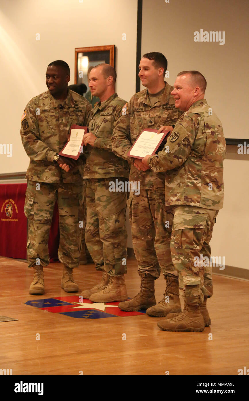 U.S. Army Sgt. 1st Class Zachary Dispennette and Sgt. Christopher Faulkner, assigned to the McDonald Army Health Center, receive their certificates from Brig. Gen. R. Scott Dingle and Command Sgt. Maj. Matthew Brady during the 2017 Best Medic Competition Award Ceremony at Fort Bragg, N.C., Sept. 20, 2017. The competition tested the physical and mental toughness, as well as the technical competence, of each medic to identify the team moving forward to represent the region at the next level of the competition.  (U.S. Army photo by Pfc. Meleesa Gutierrez) Stock Photo