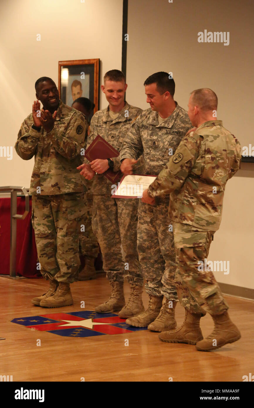 U.S. Army Brig. Gen. R. Scott Dingle and Command Sgt. Maj. Matthew Brady, Regional Health Command - Atlantic, present awards to Staff Sgt. Steven Vasko and Staff Sgt. Tyler Sheeks during the 2017 Best Medic Competition Award Ceremony at Fort Bragg, N.C., Sept. 20, 2017. The competition tested the physical and mental toughness, as well as the technical competence, of each medic to identify the team moving forward to represent the region at the next level of the competition.  (U.S. Army photo by Pfc. Meleesa Gutierrez) Stock Photo