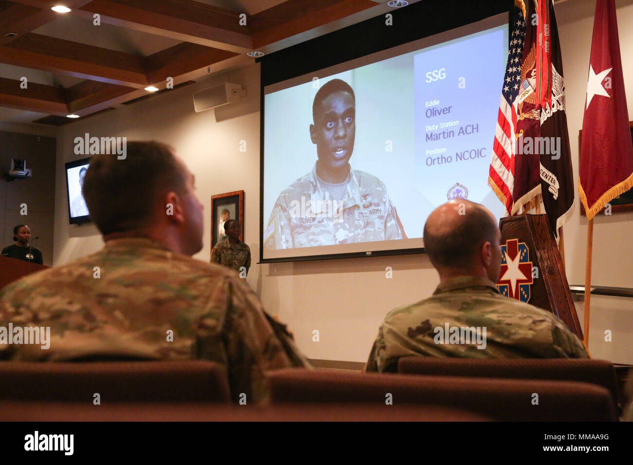 U.S. Army Sgt. Christopher Faulkner and Sgt. 1st Class Zachary Dispennette, assigned to the McDonald Army Health Center, watch the Best Medic Video during the 2017 Best Medic Competition Award Ceremony at Fort Bragg, N.C., Sept. 20, 2017. The competition tested the physical and mental toughness, as well as the technical competence, of each medic to identify the team moving forward to represent the region at the next level of the competition.  (U.S. Army photo by Pfc. Meleesa Gutierrez) Stock Photo