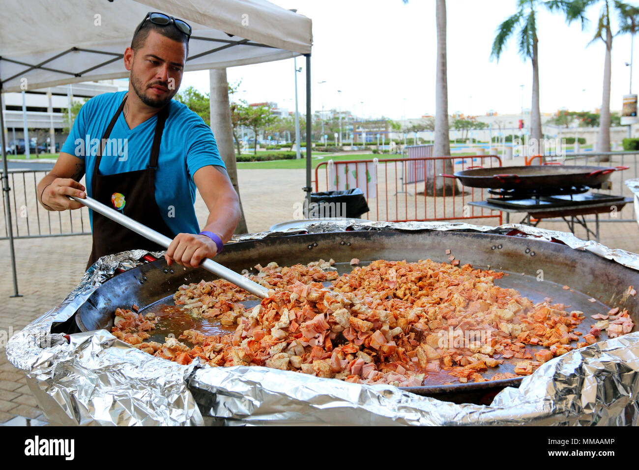 Alejandro Torres, a native of San Juan, Puerto Rico and chef volunteering with the non-profit organization, World Central Kitchen, prepares food for residents of Puerto Rico at the José Miguel Agrelot Coliseum of Puerto Rico in San Juan, Puerto Rico, Oct. 3, 2017. WCK prepared to feed approximately 46,000 residents of Puerto Rico. Chef Jose Andres, the founder of WCK, is supporting the Federal Emergency Management Agency in helping those affected by Hurricane Maria to minimize suffering as part of the overall whole-of-government response efforts. (U.S. Army photo by Pvt. Alleea Oliver) Stock Photo