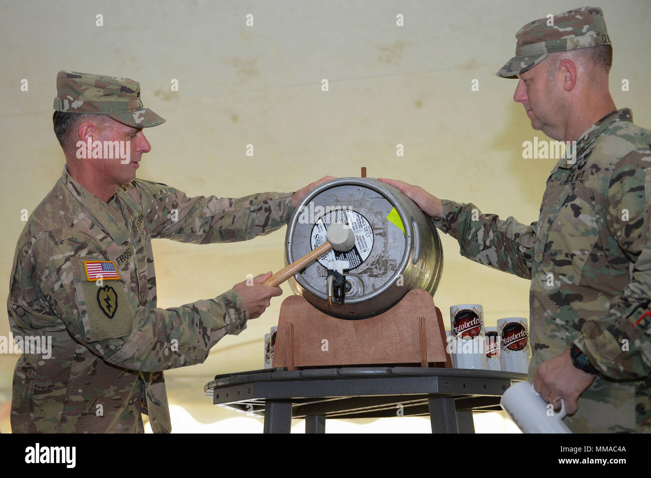 From left, U.S. Army Maj. Gen. Malcolm B. Frost, Center for Initial Military Training commanding general, and Col. Ralph L. Clayton III, 733rd Mission Support Group commander, tap the keg to officially start the Oktoberfest celebration at Joint Base Langley-Eustis, Va., Sept. 22, 2017. The first Oktoberfest was held in 1810 in Munich, Germany, to honor the marriage between Prince Ludwig and Therese of Saxe-Hildburghausen. (U.S. Air Force photo by Airman 1st Class Kaylee Dubois) Stock Photo