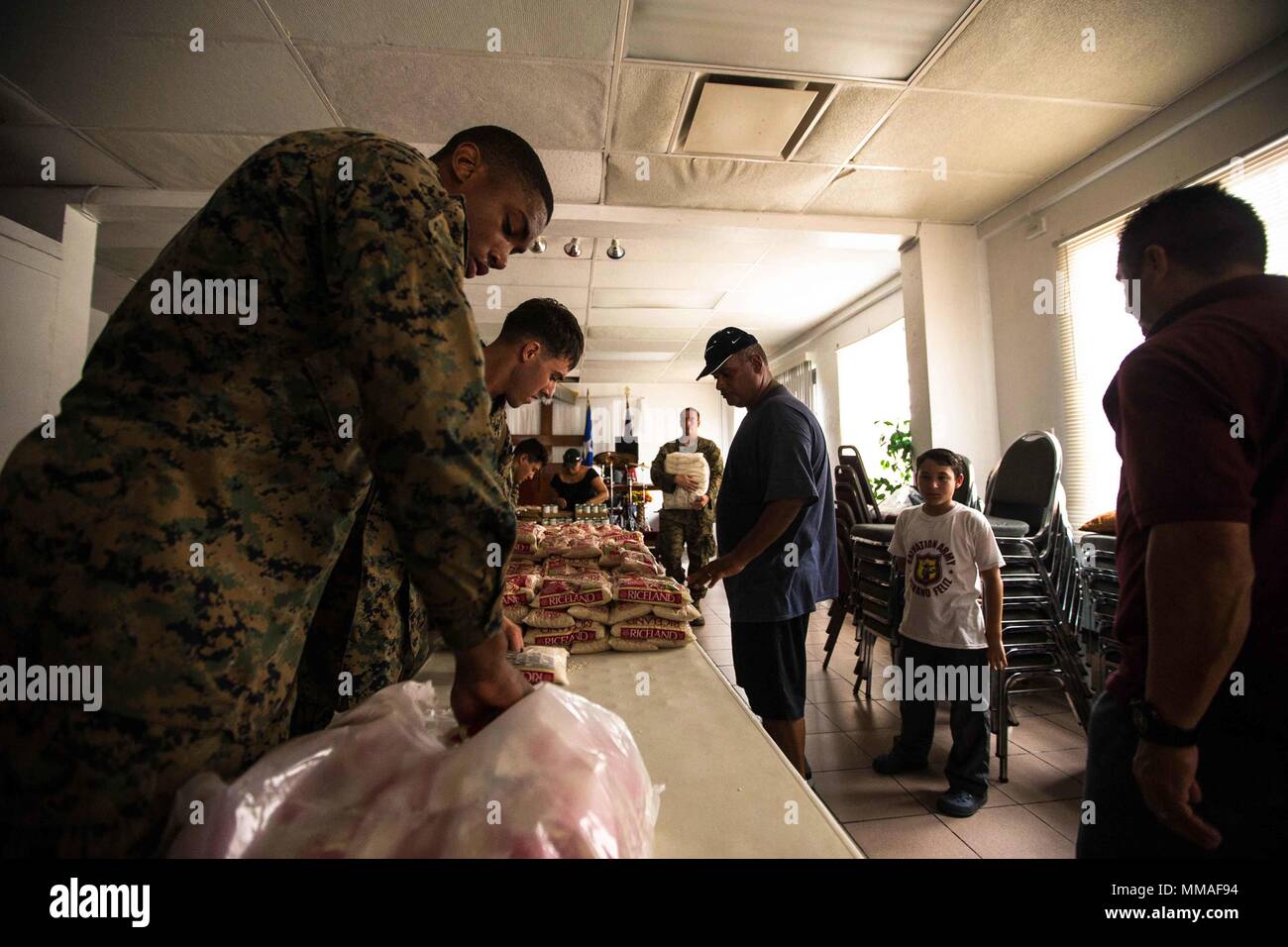 U.S. Marine Corps Lance Cpl. Rael G. Pascall, left, an embark specialist with the 26th Marine Expeditionary Unit (MEU), helps stock food for the community at a local Salvation Army as part of relief efforts for victims of Hurricane Maria in Fajardo, Puerto Rico, Oct. 3, 2017. The 26th MEU, along with local authorities and other Department of Defense services, is supporting the lead federal agency, Federal Emergency Management Agency, in providing humanitarian aid efforts for Puerto Rico. (U.S. Marine Corps photo by Lance Cpl. Tojyea G. Matally) Stock Photo