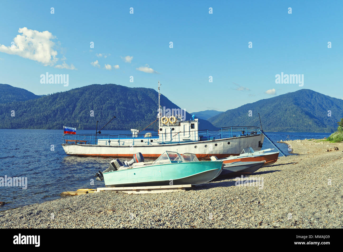 Siberia, Teletskoye lake. Passenger vessel and motor boats moored near the shore Stock Photo