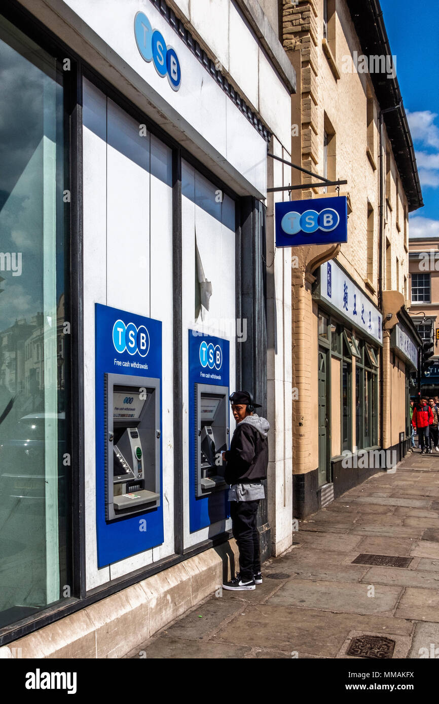 London,Greenwich. Young man using at cash machine to draw money.TSB High street bank ATM Stock Photo