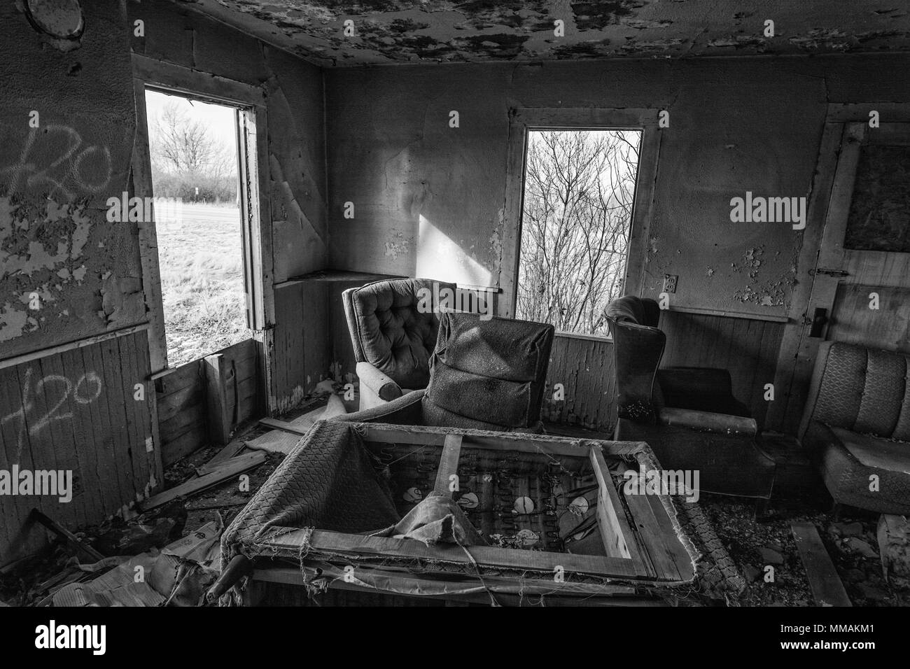 The inside of an abandoned house. This house has been abandoned for years and is showing the signs of vandalism and deterioration. Stock Photo