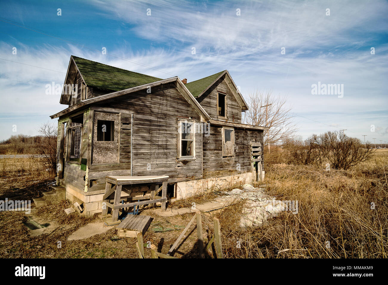 Photo of an old scary abandoned farm house that is deteriorating with time and neglect. Stock Photo