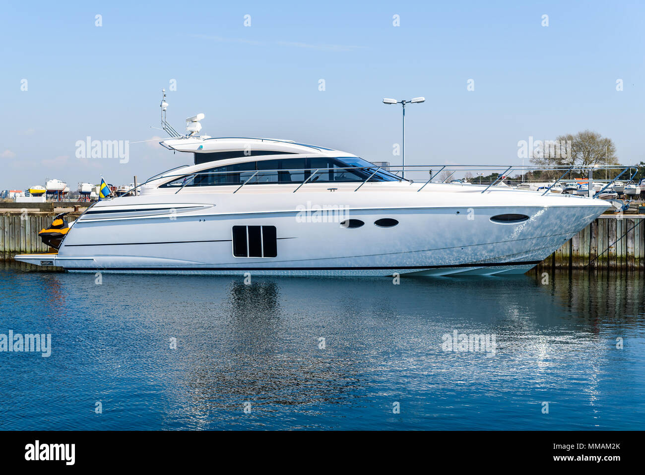 Luxurious motorboat tied to a pier. Logos and id removed. Stock Photo