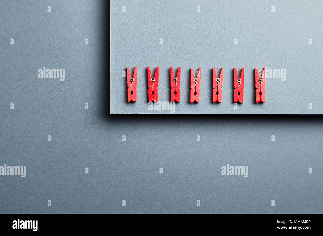 Red laundry clips organized over dark gray background, top view Stock Photo