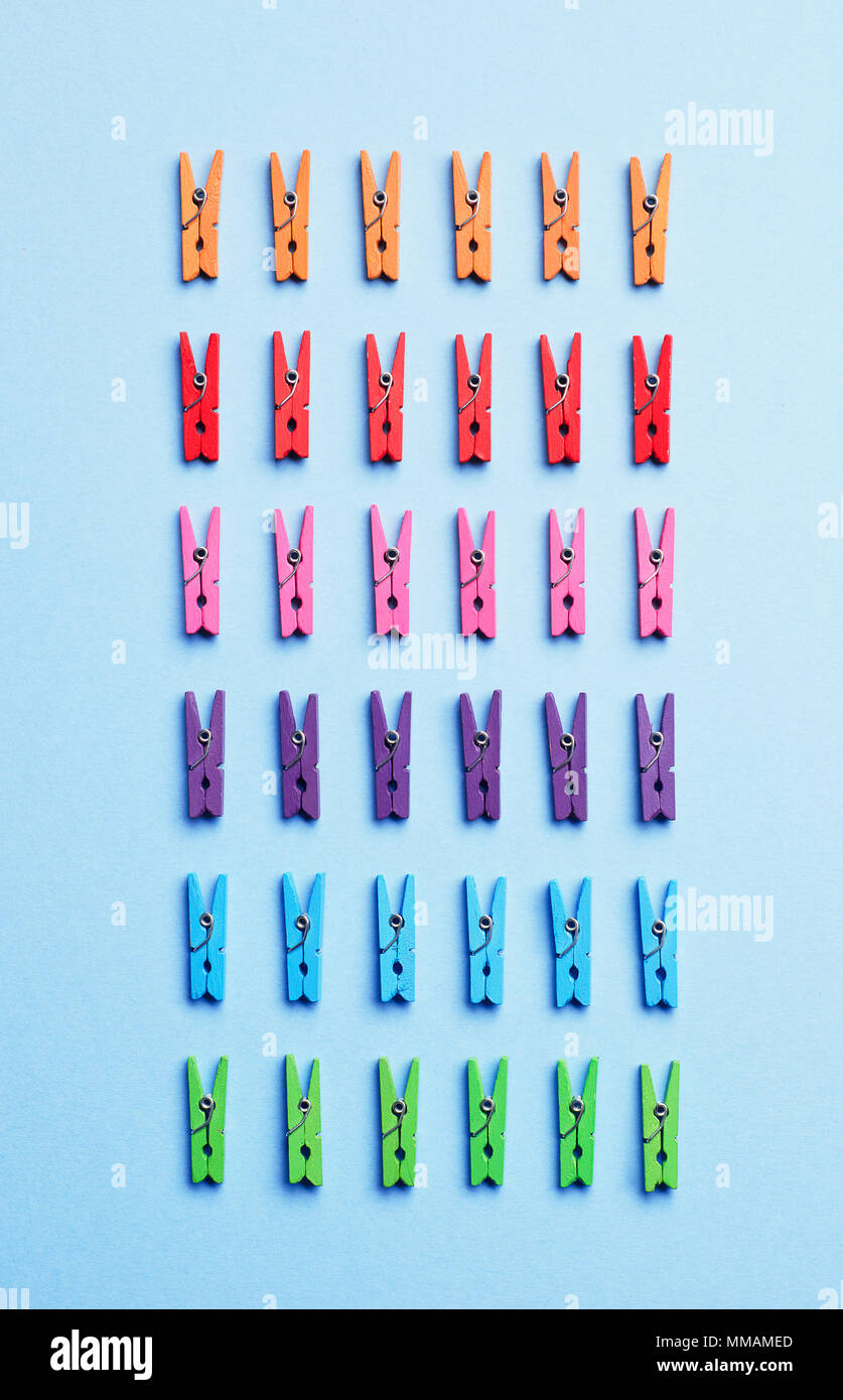 Laundry clips organized over blue background, top view Stock Photo