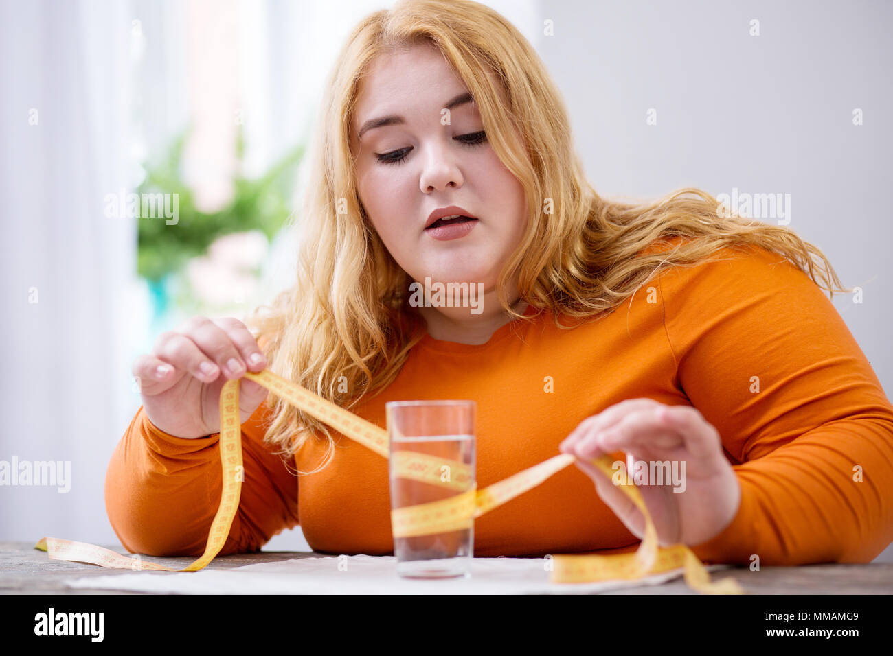 Fat woman holding a measuring tape Stock Photo