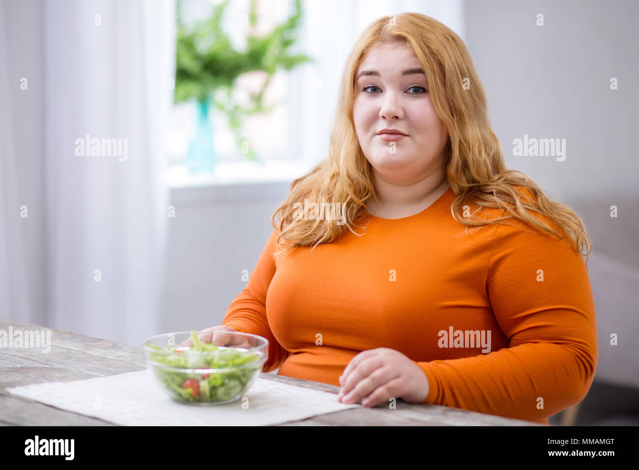 Smiling stout woman having breakfast Stock Photo