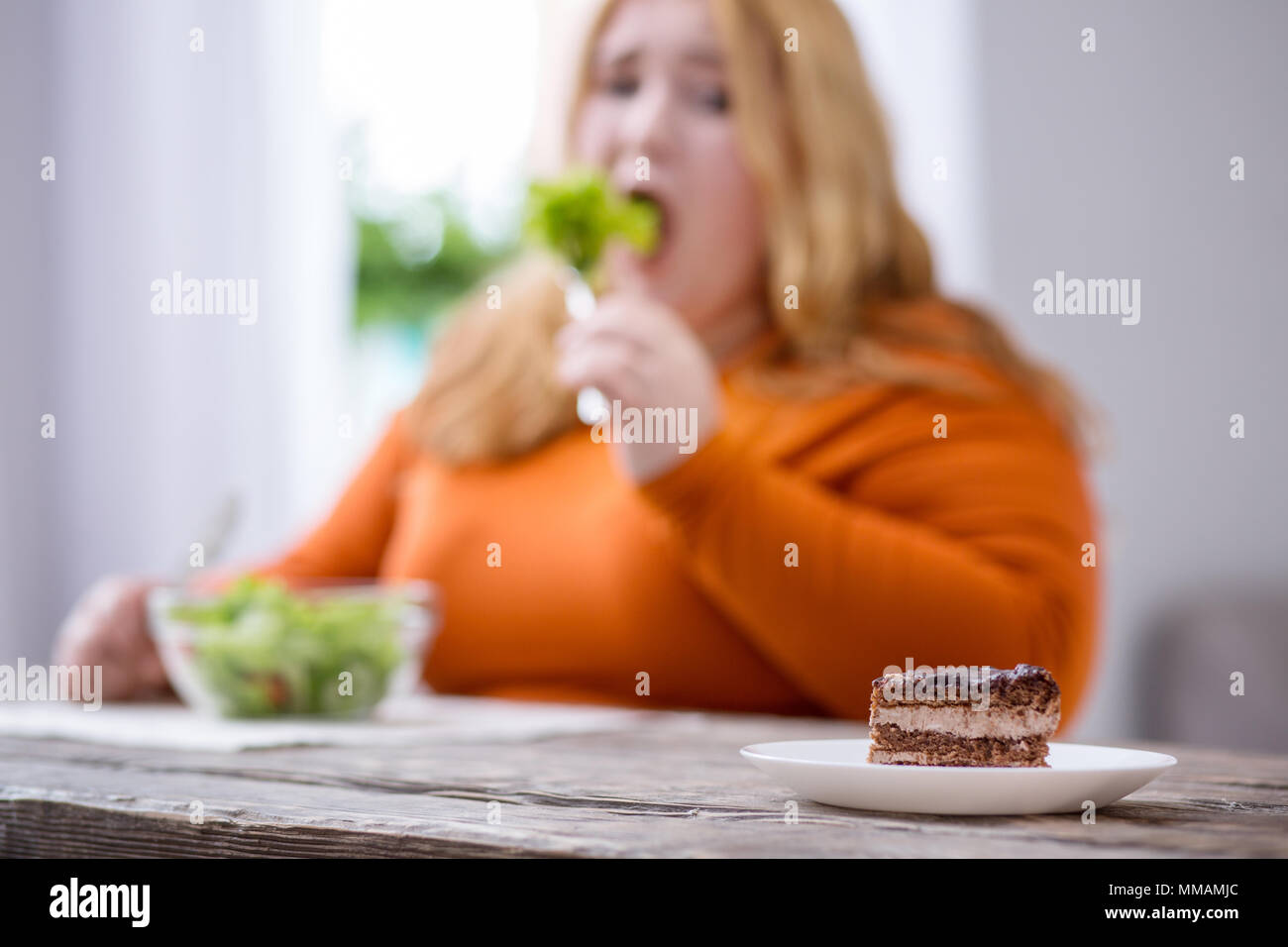 Desolate plump woman looking at cookies Stock Photo