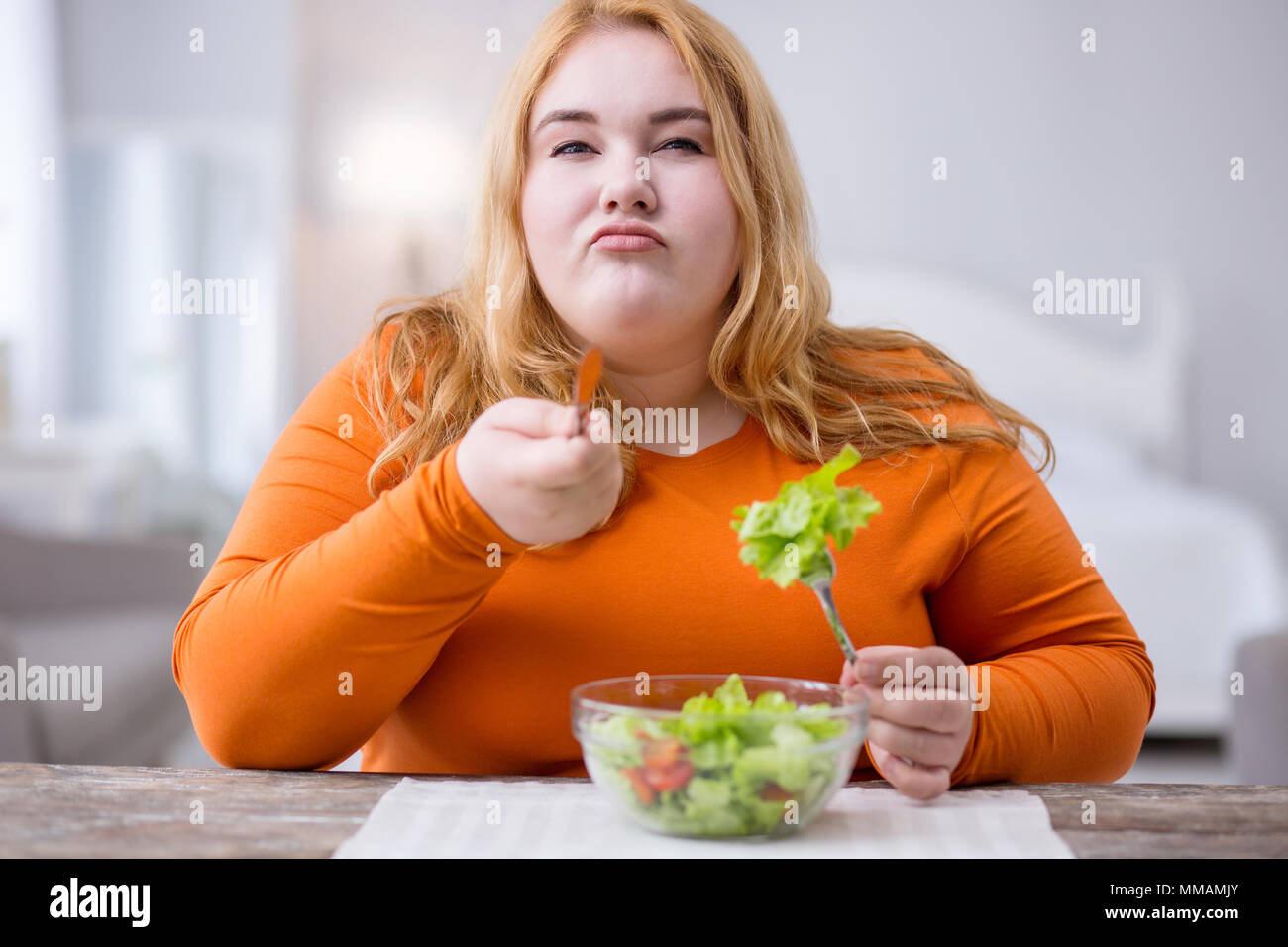 Determined fat woman eating healthy breakfast Stock Photo