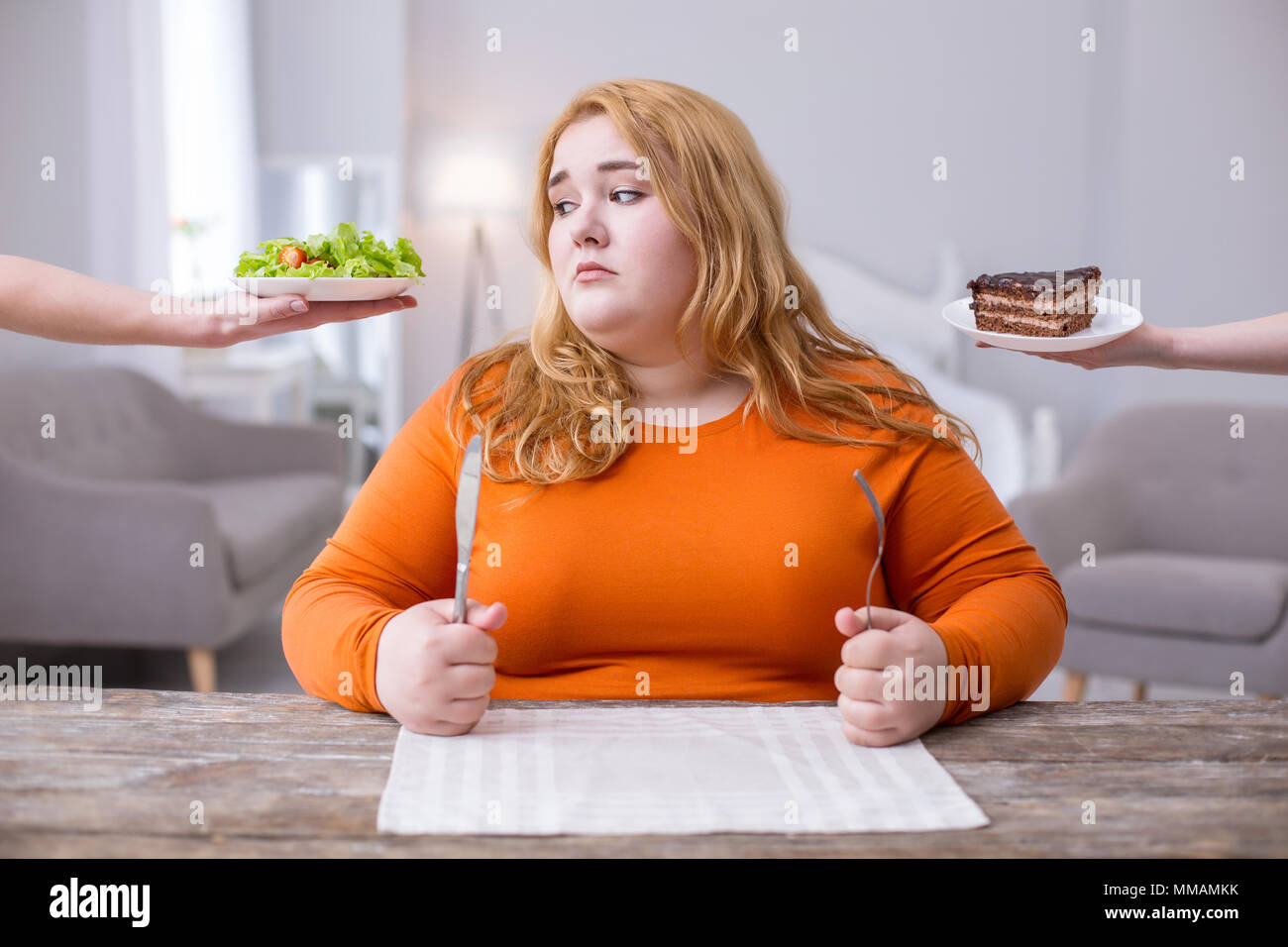 Unhappy fat woman looking at a salad Stock Photo