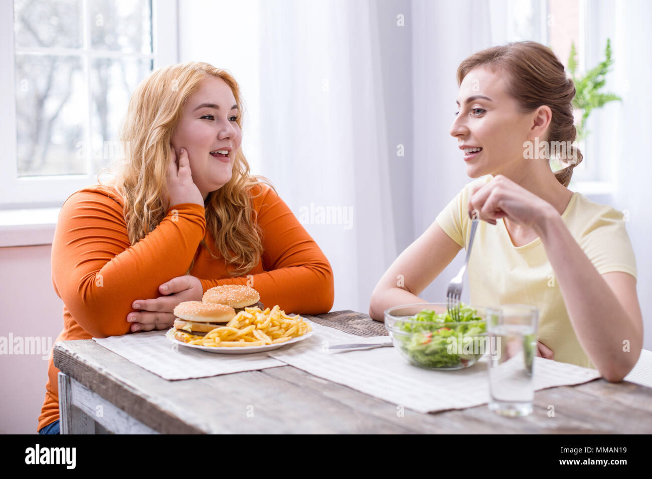 Happy fat woman having lunch with her friend Stock Photo