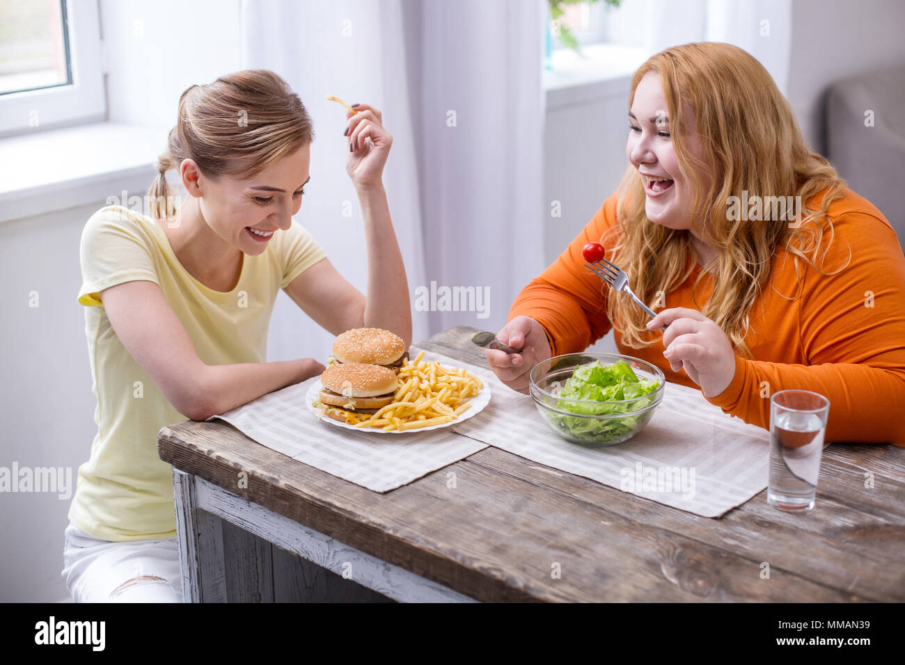 Smiling slim woman having lunch with her friend Stock Photo