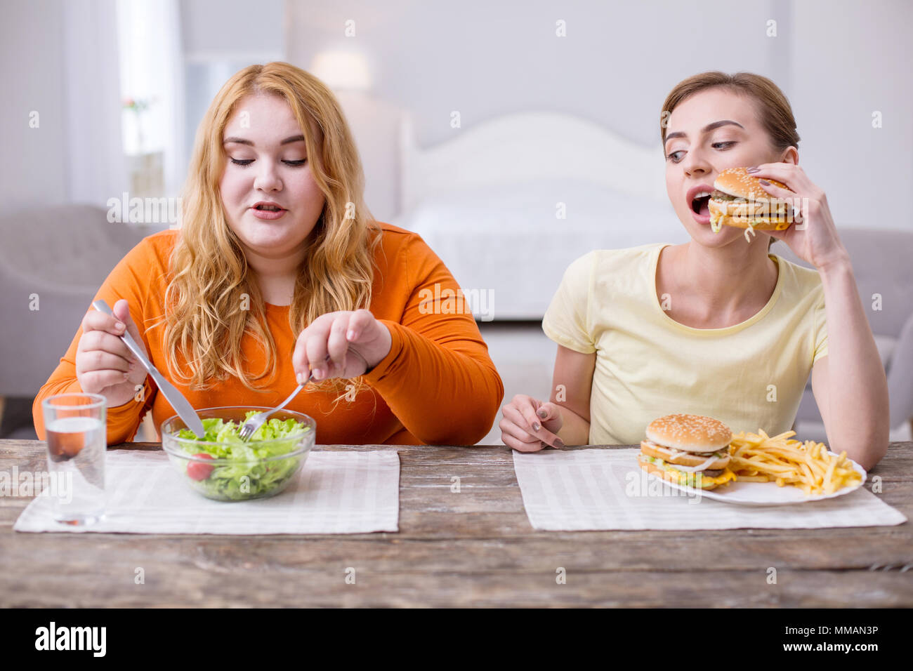 Concentrated slim woman having lunch with her friend Stock Photo