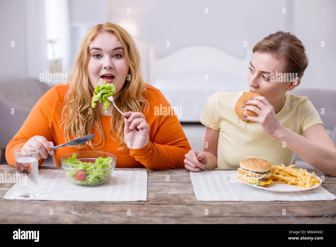 Content plump woman having lunch with her friend Stock Photo