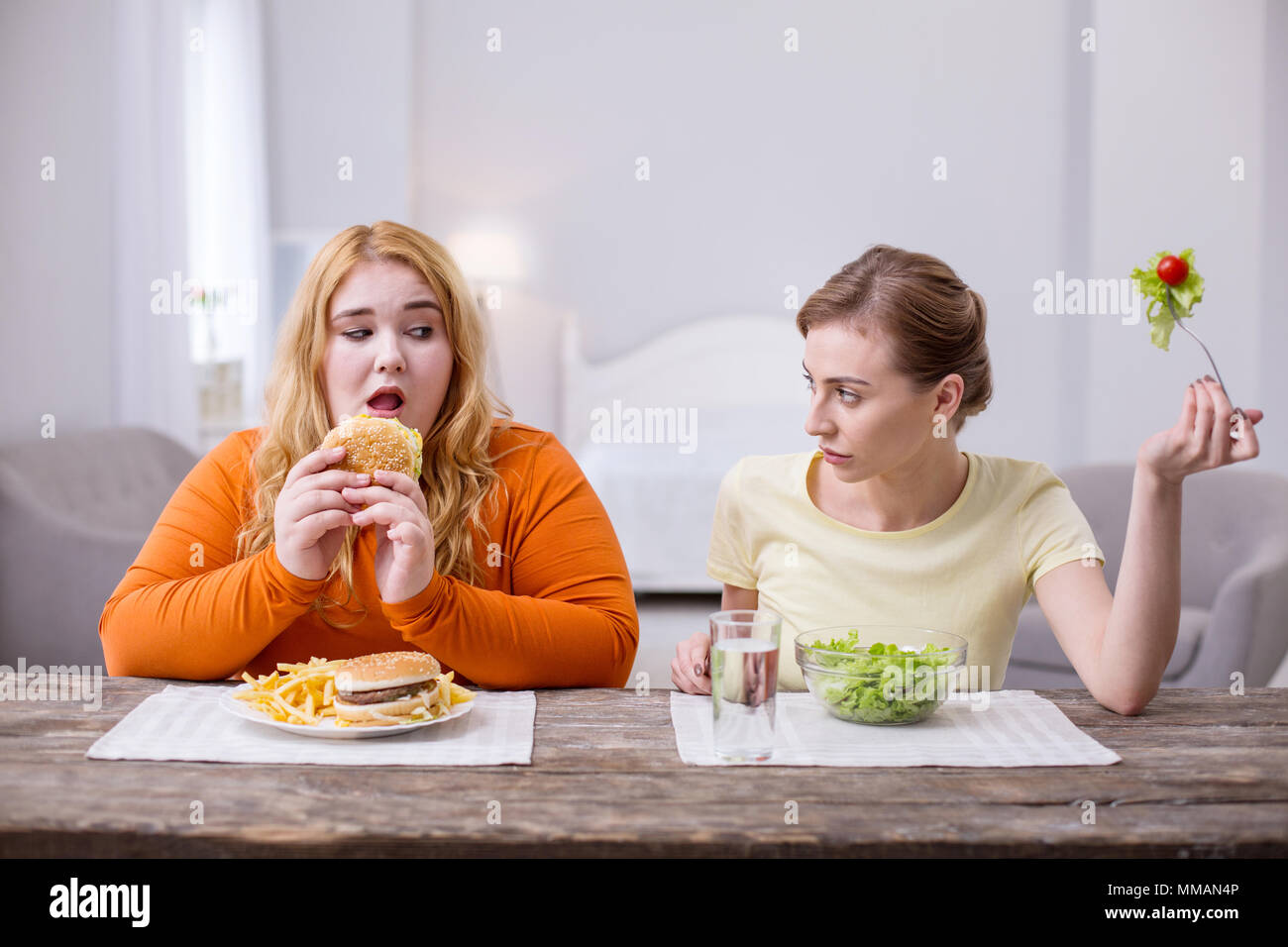 Excited plump woman having lunch with her friend Stock Photo