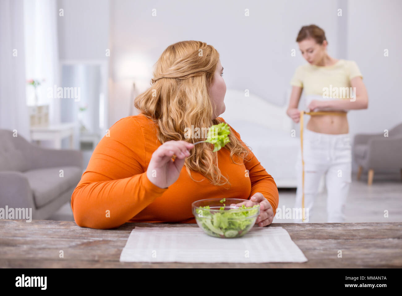 Fat woman looking at her slim friend Stock Photo