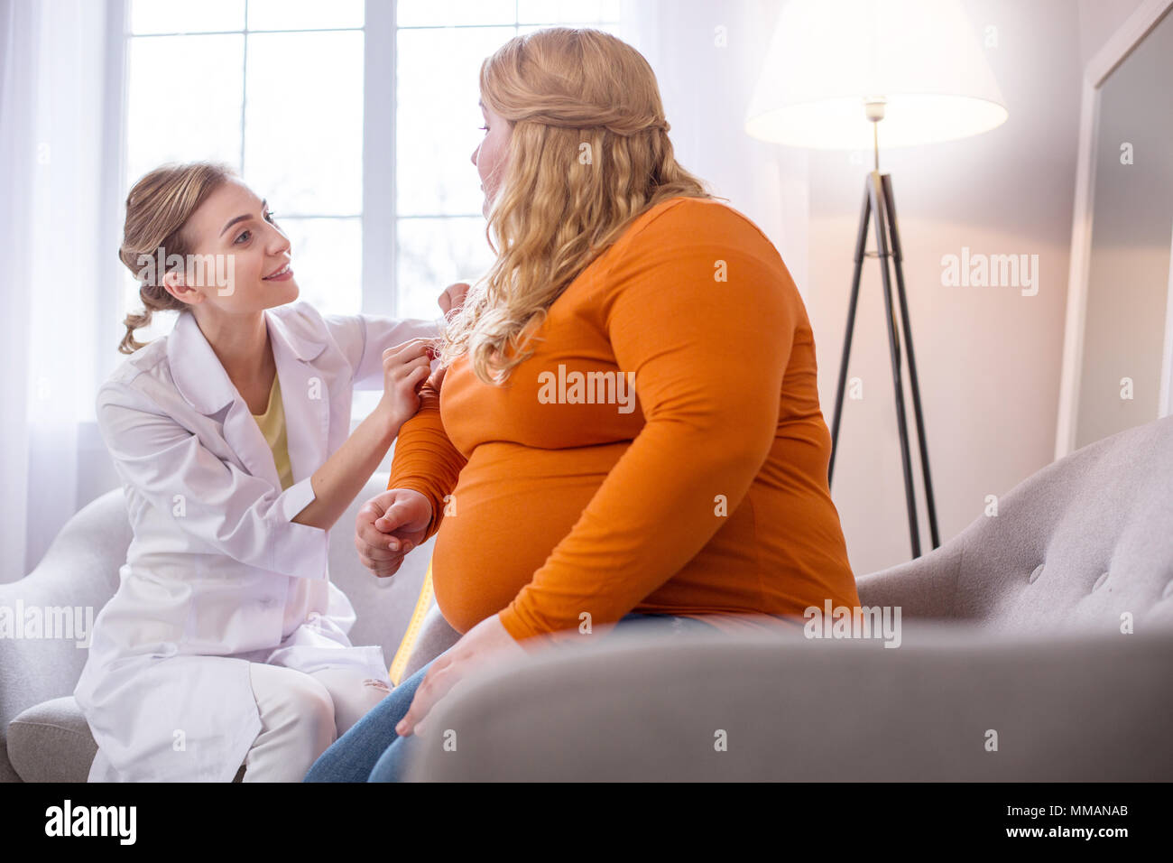 Cheerful nutritionist talking with a plump woman Stock Photo