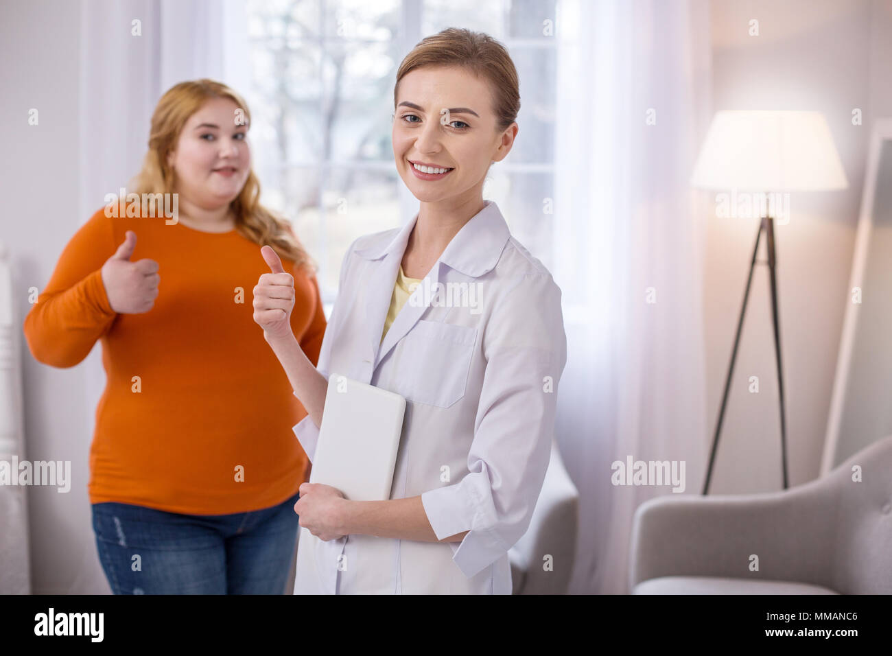 Cheerful nutrition specialist showing her thumb up Stock Photo