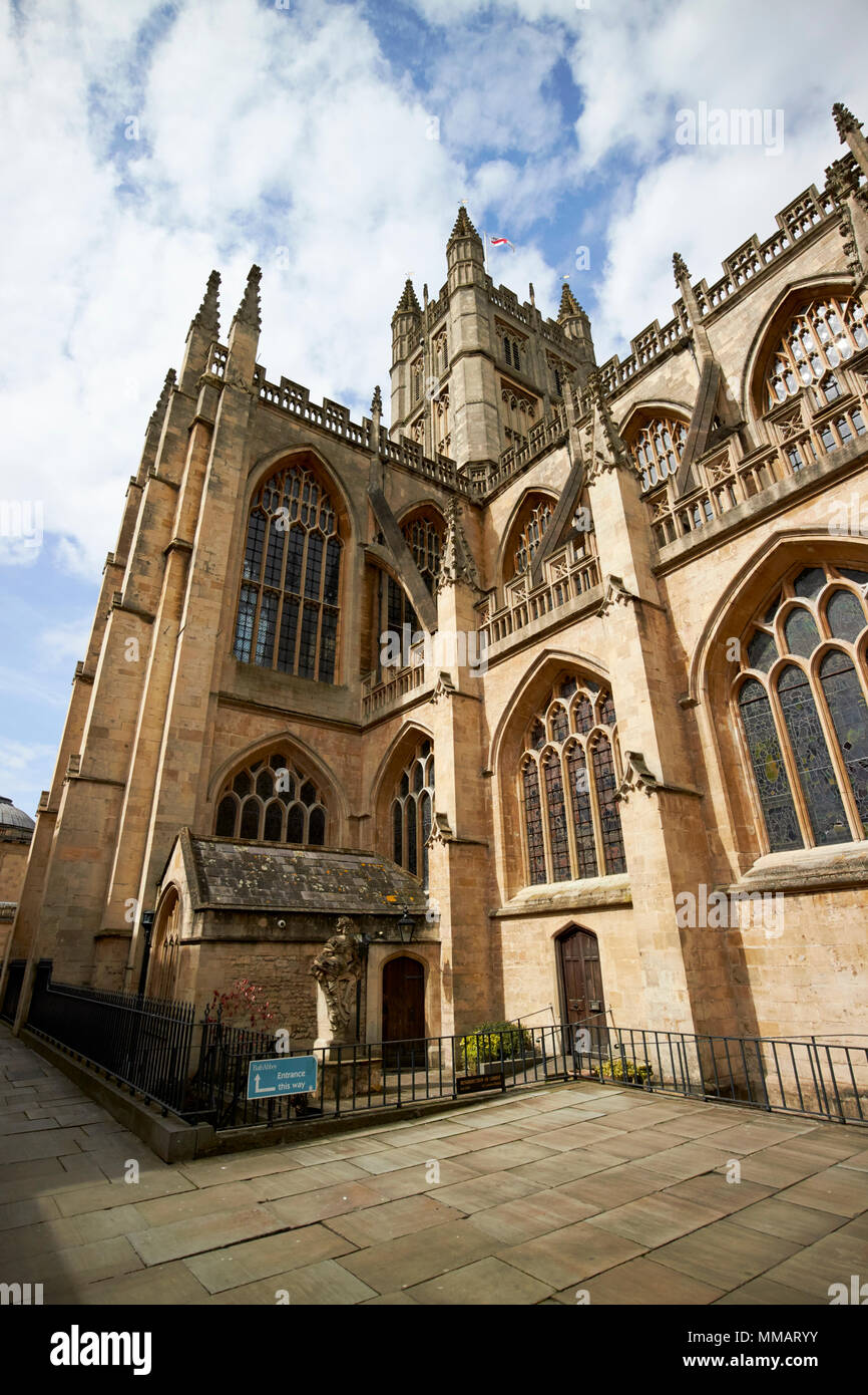 corner view looking up at flying buttresses, battlements, pinnacles and parapets beneath the tower of gothic bath abbey Bath England UK Stock Photo