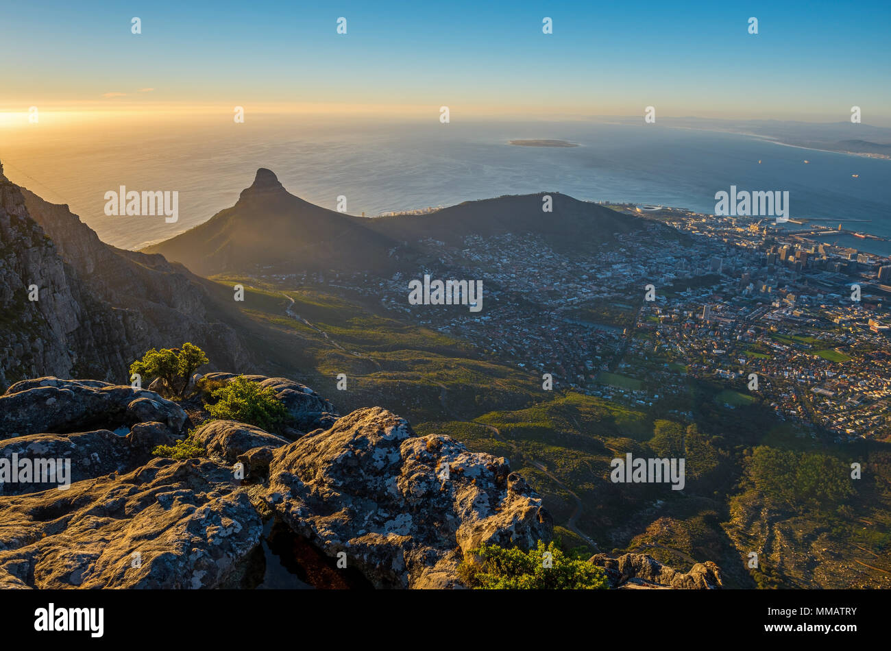 Sunset with aerial view over Cape Town and its urban skyline and the famous lion's head mountain peak as seen from the Table Mountain, South Africa. Stock Photo