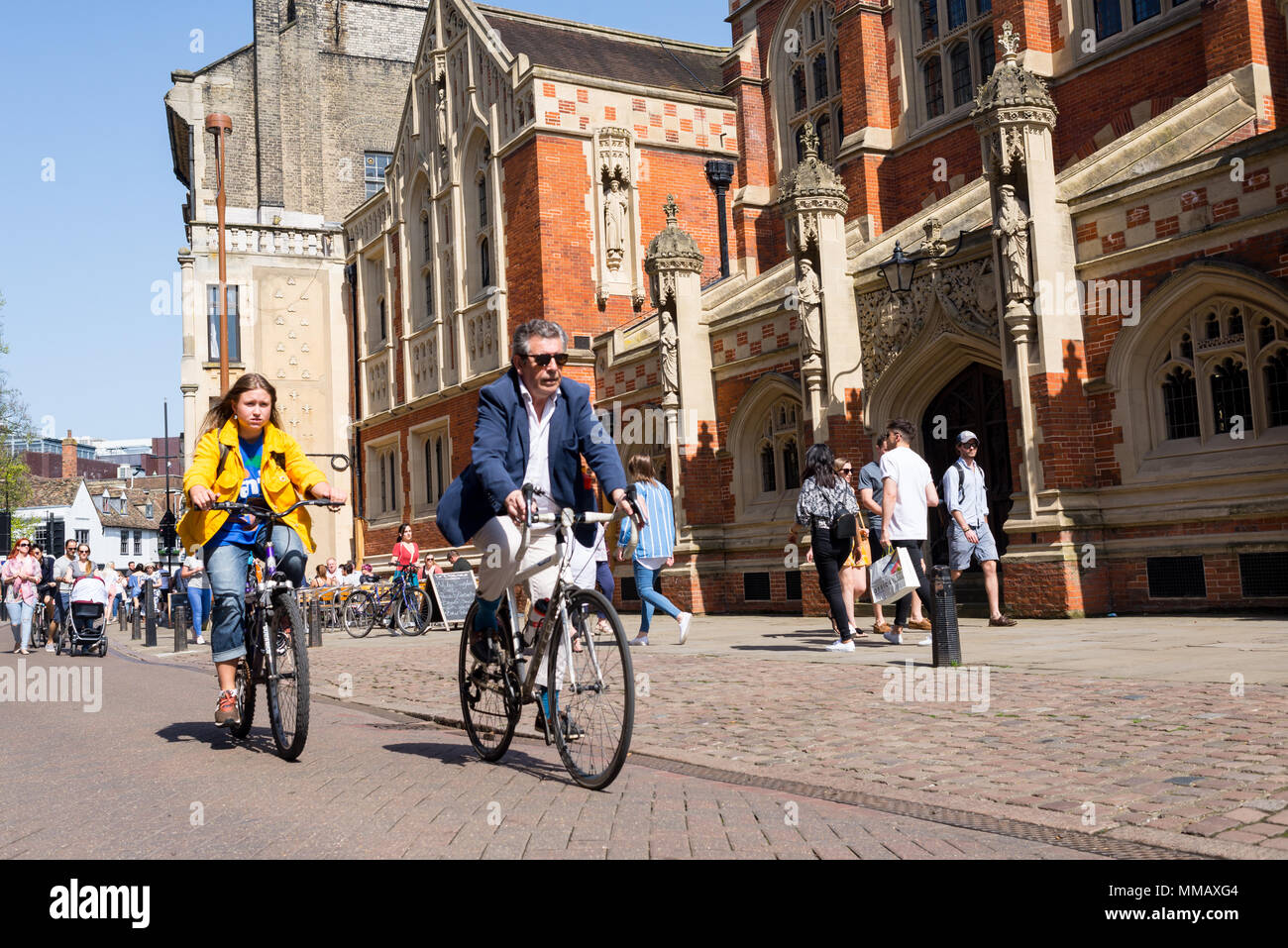 Cambridge, UK -April 2018. People cycling next to Old Divinity School in St Johns street, central Cambridge city centre Stock Photo