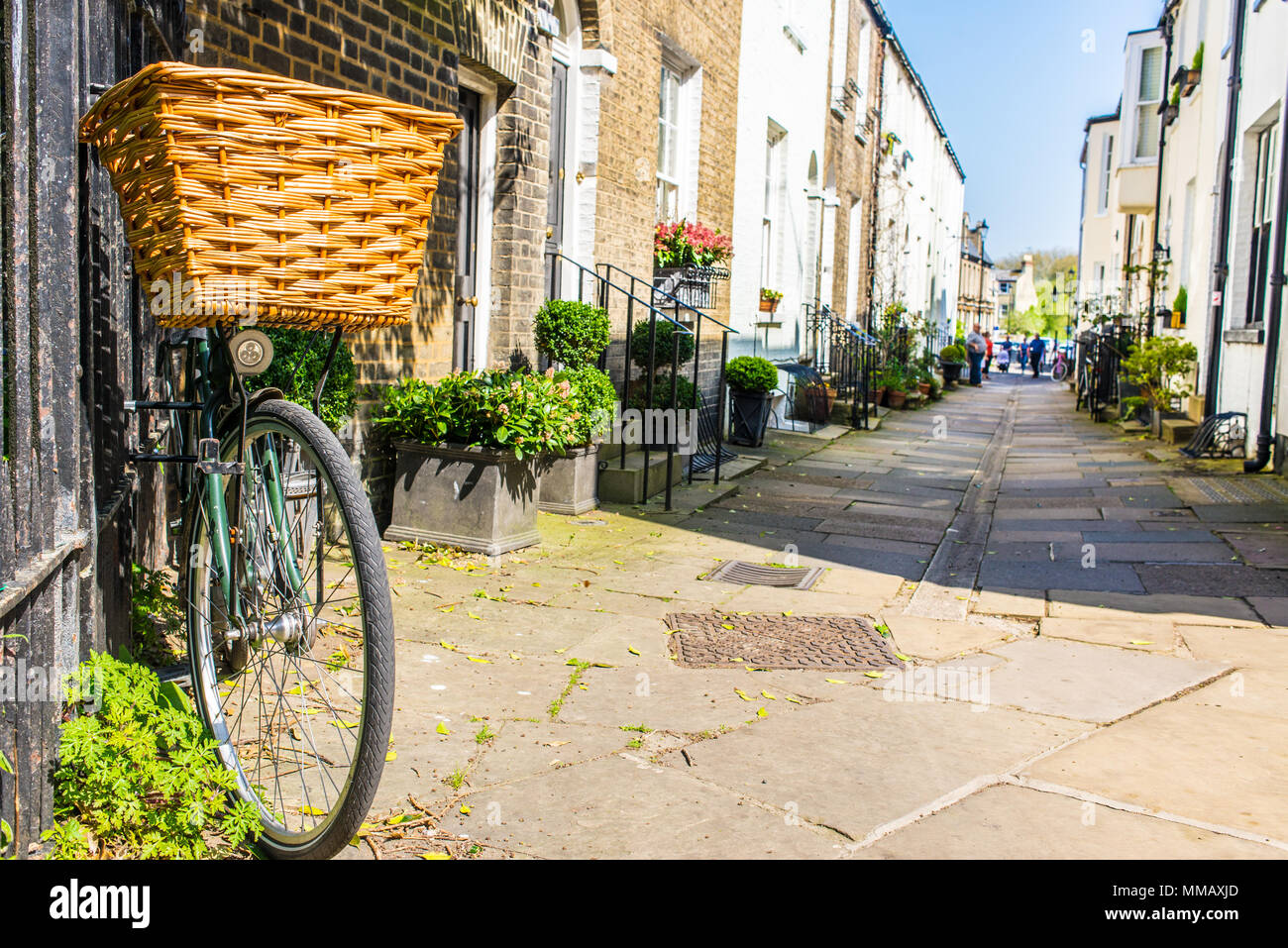 Bike parked against a wall in a small traditional British street mews with classic English Victorian houses in a sunny day Stock Photo