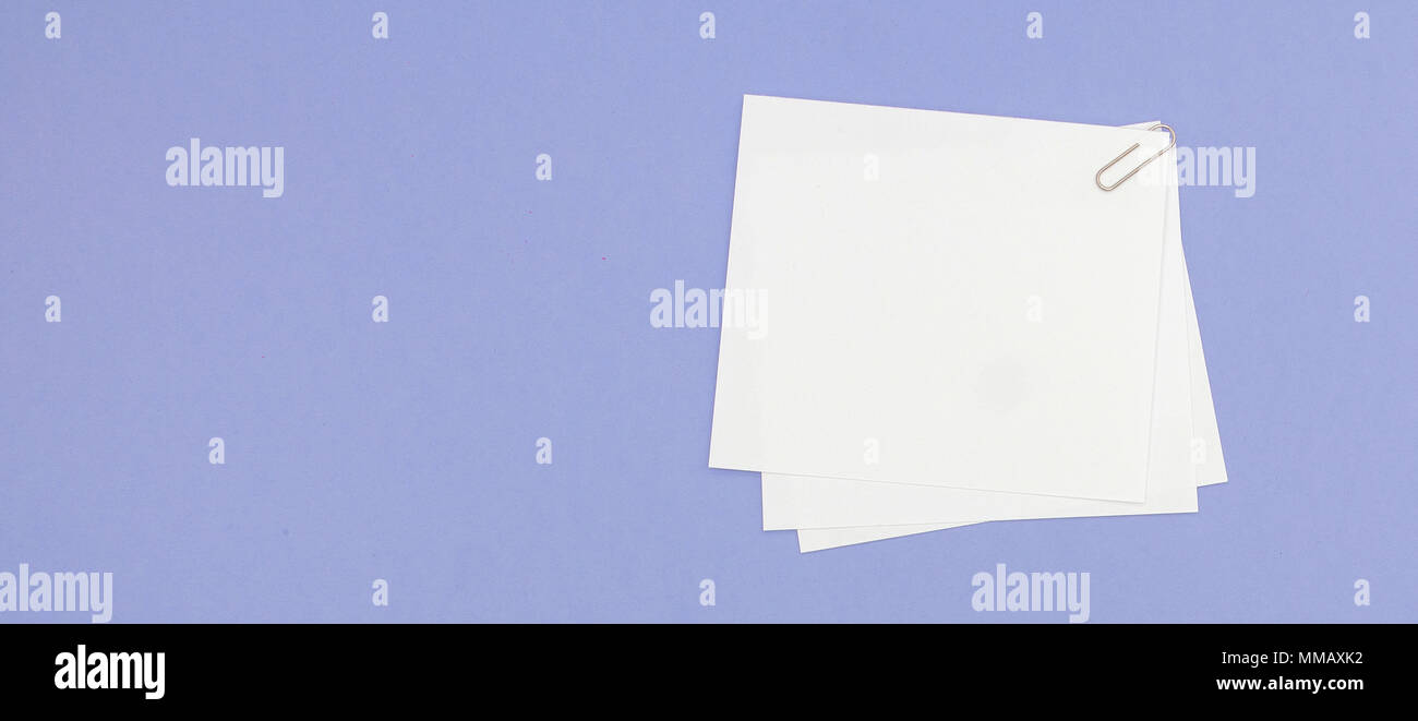 Blank note papers label with clip on purple background. Stock Photo