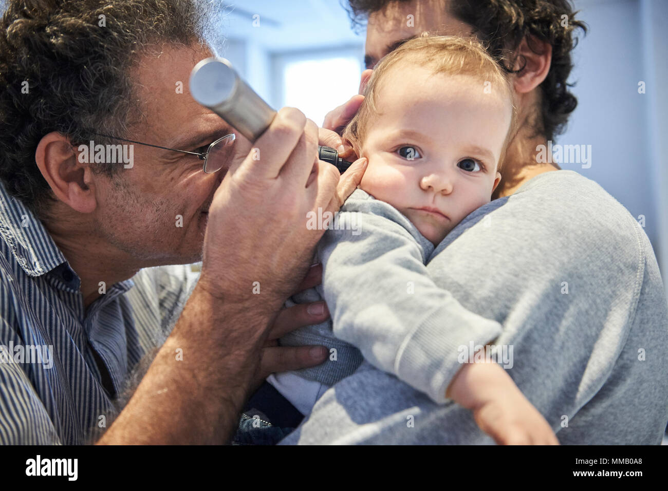 Nose and throat examination otoscope pediatrics pediatrician health professional hires stock