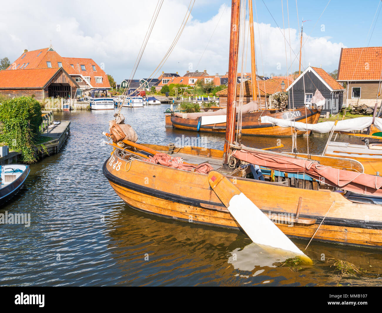 Traditional flatbottom fishing boats moored in shipyard Blazerhaven in historic town of Workum, Friesland, Netherlands Stock Photo
