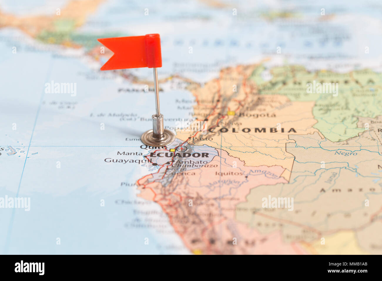 Small red flag marking the South American country of  Ecuador on a world map. Stock Photo