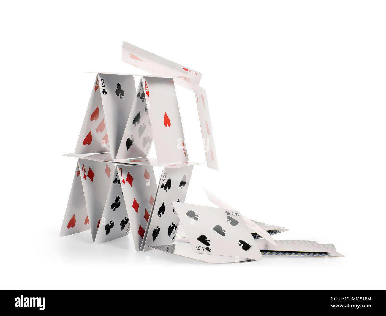 Crashed house of cards. Falling cards isolated on white, clipping path included Stock Photo