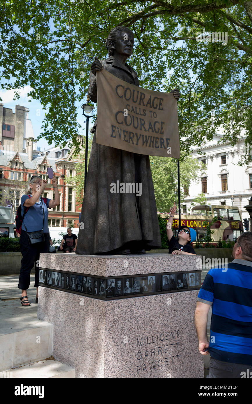 Admirers of suffragist Millicent Garrett Fawcett's statue, the first woman to appear among an all-male Parliament Square, on 9th May 2018, in London, England. Dame Millicent Garrett Fawcett GBE was a British feminist, intellectual, political leader, activist and writer. She is primarily known for her work as a campaigner for women's suffrage Stock Photo
