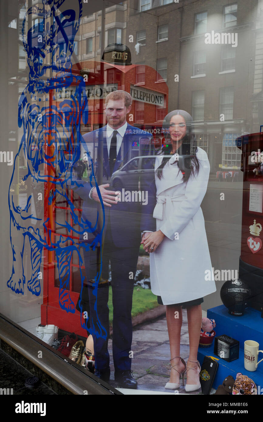 A week before the royal wedding between Prince Harry and Meghan Markle, their life-size cut-outs have been positioned behind the outline of a British Bulldog in the window of a tourist trinket shop near Piccadilly Circus, on 9th May, in London, England. Stock Photo