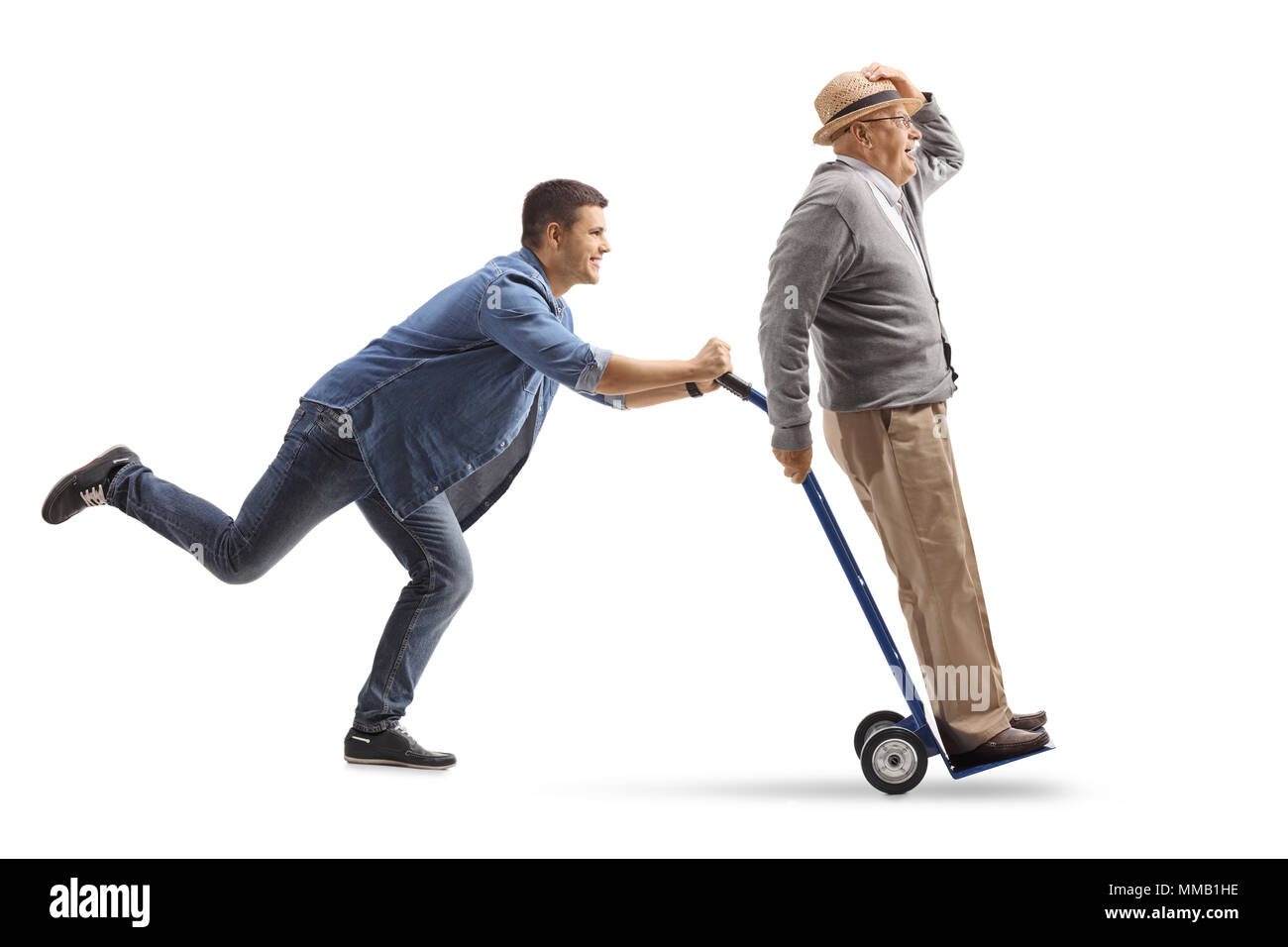 full-length-profile-shot-of-a-young-man-pushing-a-hand-truck-with-a-mature-man-riding-on-it-isolated-on-white-background-MMB1HE.jpg