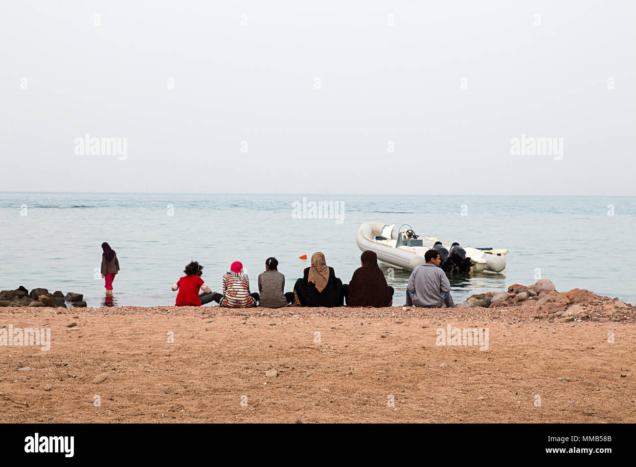 Bedouin familiy on beach Dahab, Sinai, Egypt. Traditional bedouin lifestyle, clothes. Fishing in Red Sea. Stock Photo