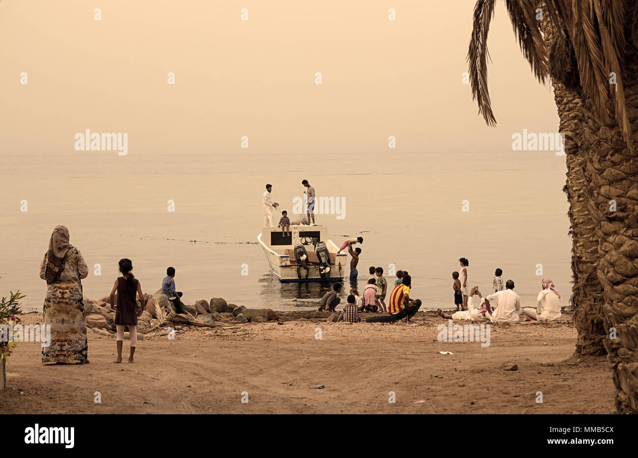 Bedouin families on beach Dahab, Sinai, Egypt. Traditional bedouin lifestyle, clothes. Fishing in Red Sea. Stock Photo