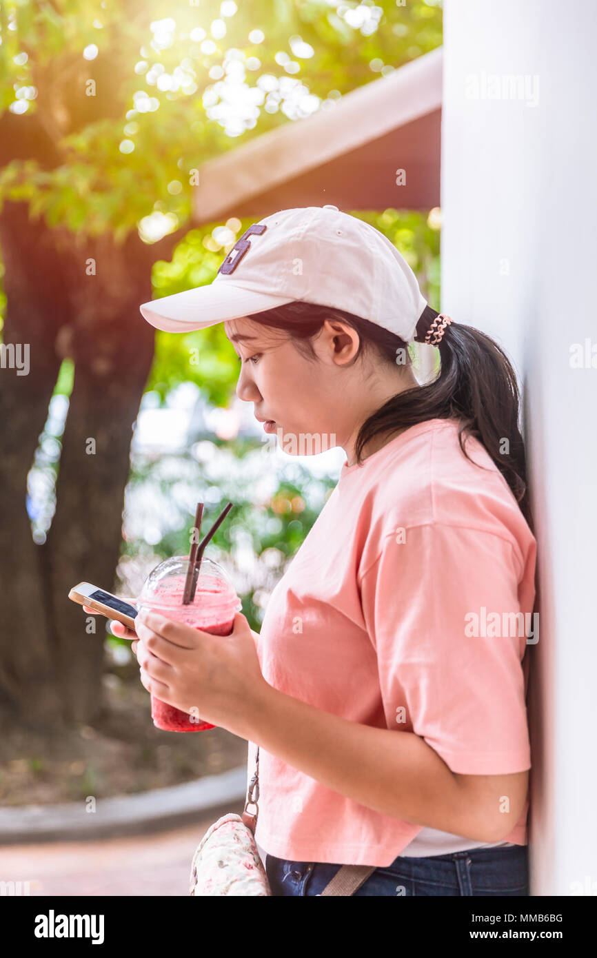 Bad habit of modern young fat girl teen behavior eat more sugar sweet dessert and playing smartphone. Stock Photo