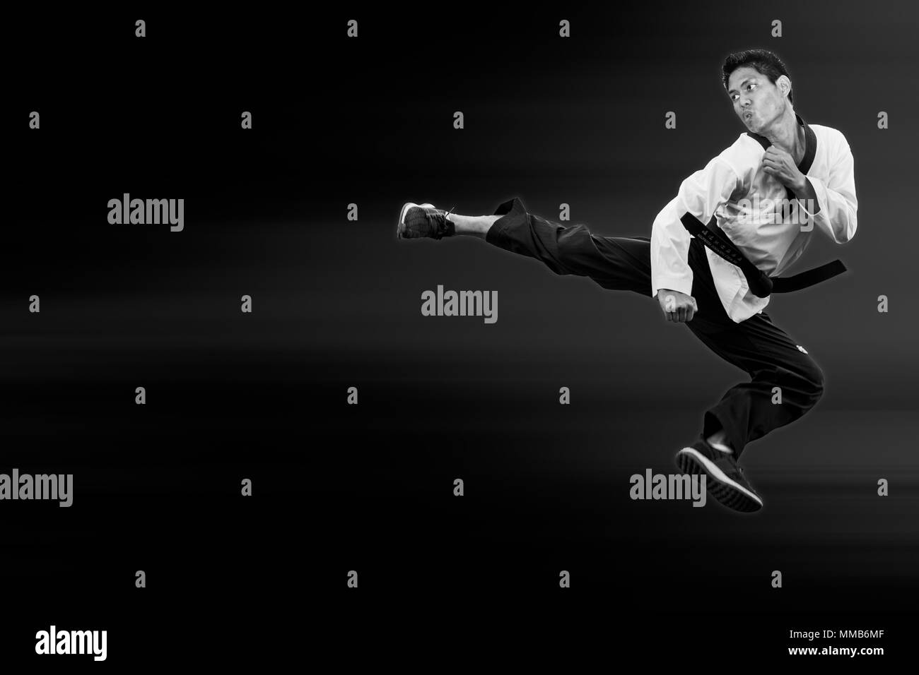 Taekwondo man jump flying high kick on black for poster background with